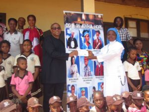 Rev. Sr Udechukwu Chidimma (right), receiving a cheque of N1 million Naira on behalf of Presentstion Nursery and Primary school, Awgbu, from Mr. Peter Obi (Left), who visited the school on Wednesday.